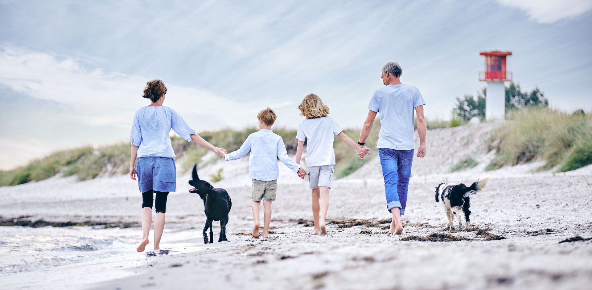 Familie mit Kindern und Hund macht Urlaub am Strand an der Ostsee