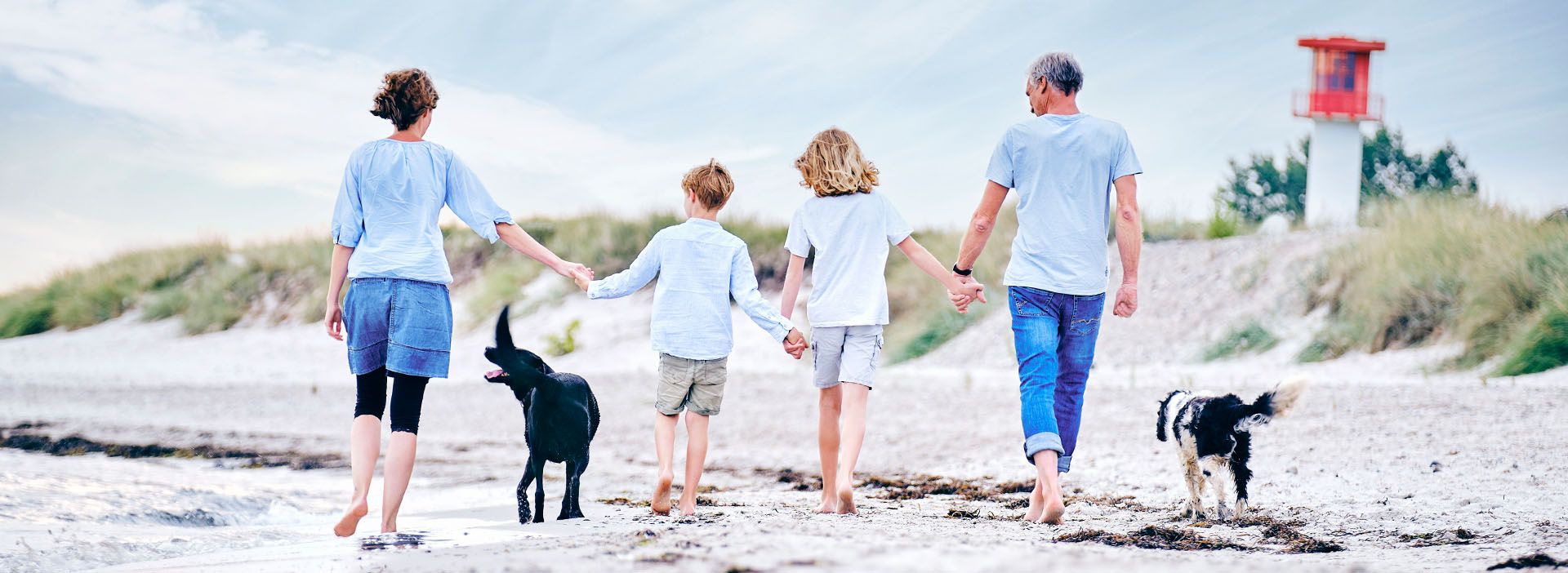 Familie mit Kindern und Hund macht Urlaub am Strand an der Ostsee